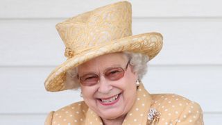 Queen Elizabeth II laughs in the Royal Box as she attends the Queen's Cup final at Guards Polo Club