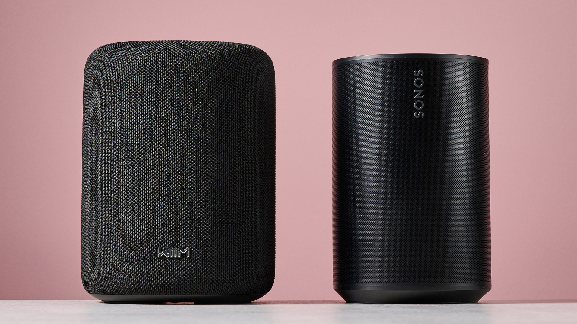 The WiiM Sound Lite side by side with the Sonos Era 100 from a front on angle.