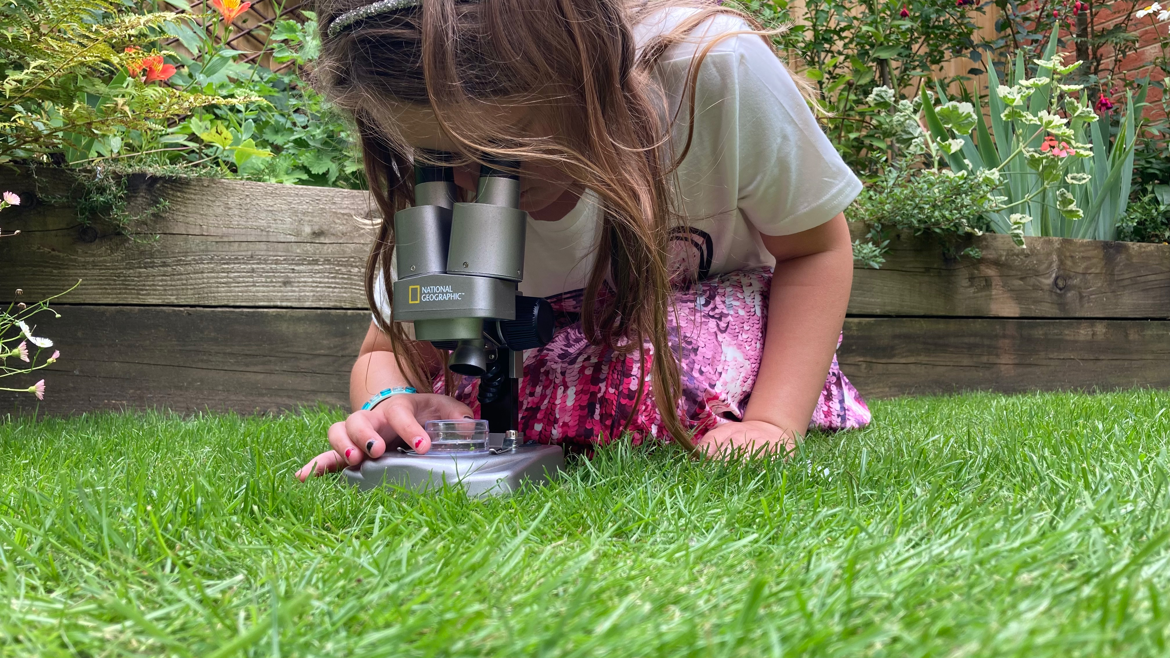 National Geographic Ultimate Dual Stereo Microscope being used by a child in a garden