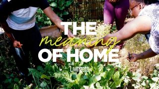 Three people, captured up close and working in a community garden, pass each other gardening tools while wearing summer clothes. Over them is a banner reading "THE Meaning OF HOME Livingetc".