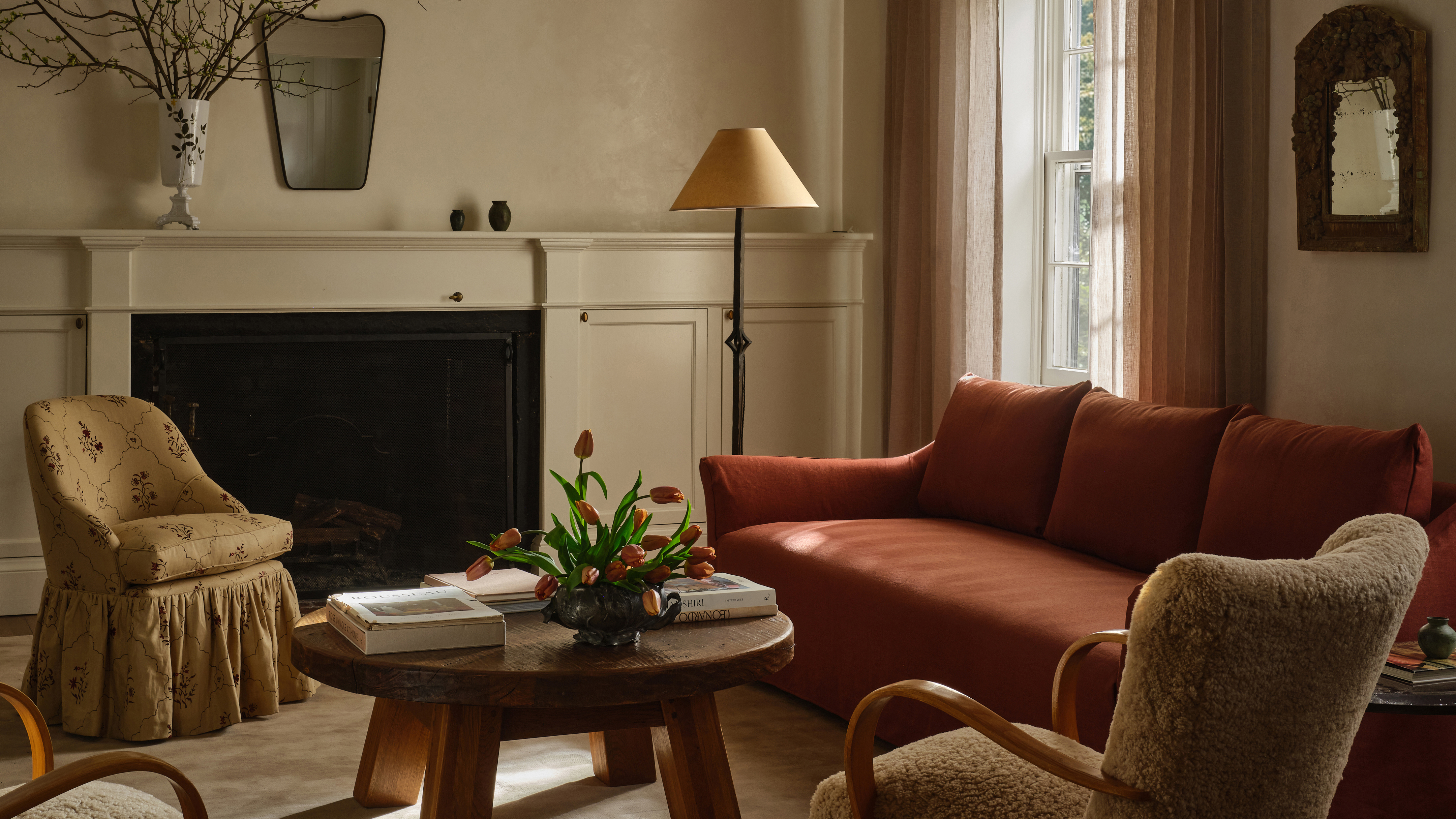 living room with rust colored sofa, and modern armchairs 