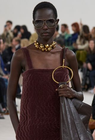 a photo of a model wearing '70s sunglasses with wire frame on the fall 2024 runway