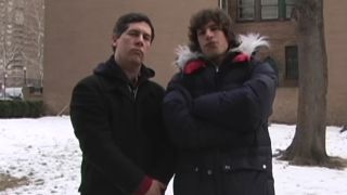 Chris Parnell and Andy Smaberg, wearing winter coats and arms crossed in Lazy Sunday video for The Lonely Island.