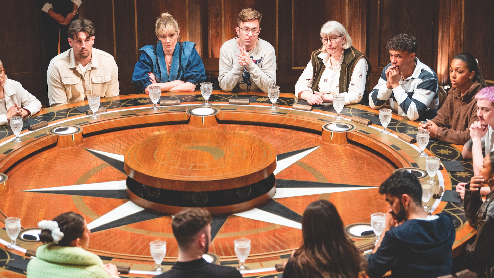Contestants from series 3 of The Traitors sit around the table