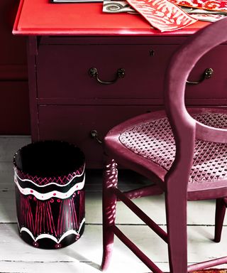 A home office with chair, desk and waste bin decorated with Annie Sloan Chalk Paint in shades Emperor's Silk Burgundy, Old White, and Capri Pink