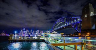 A wide-angle view of the Sydney skyline and Harbour Bridge during Vivid Sydney