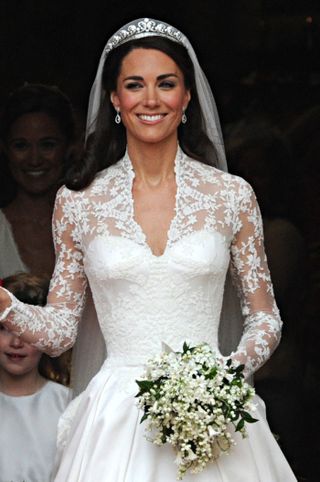 Kate middleton at her 2011 wedding to prince william wearing a lace dress with a full white skirt