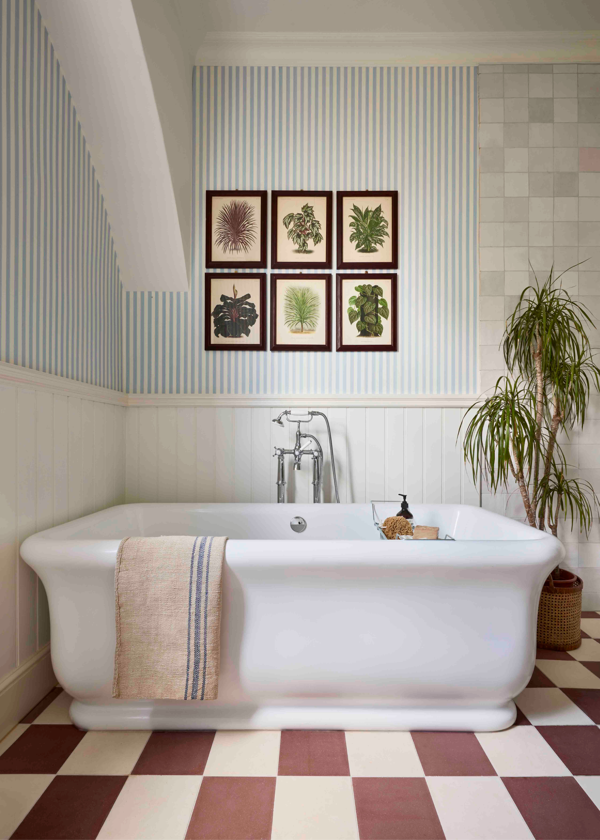 freestanding bath with striped walls and red and cream checkerboard tiles