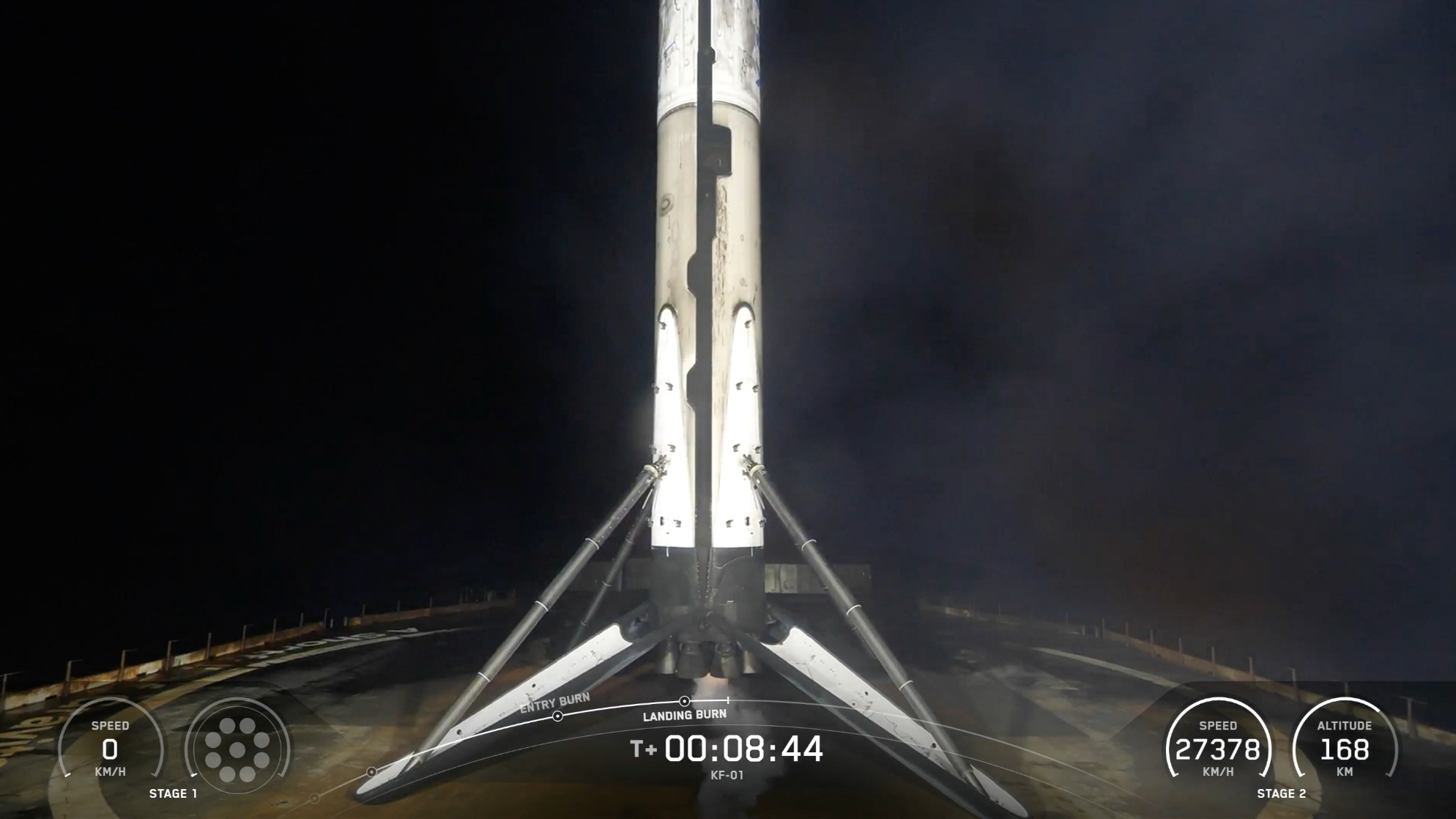 a white rocket rests on the deck of a ship at night