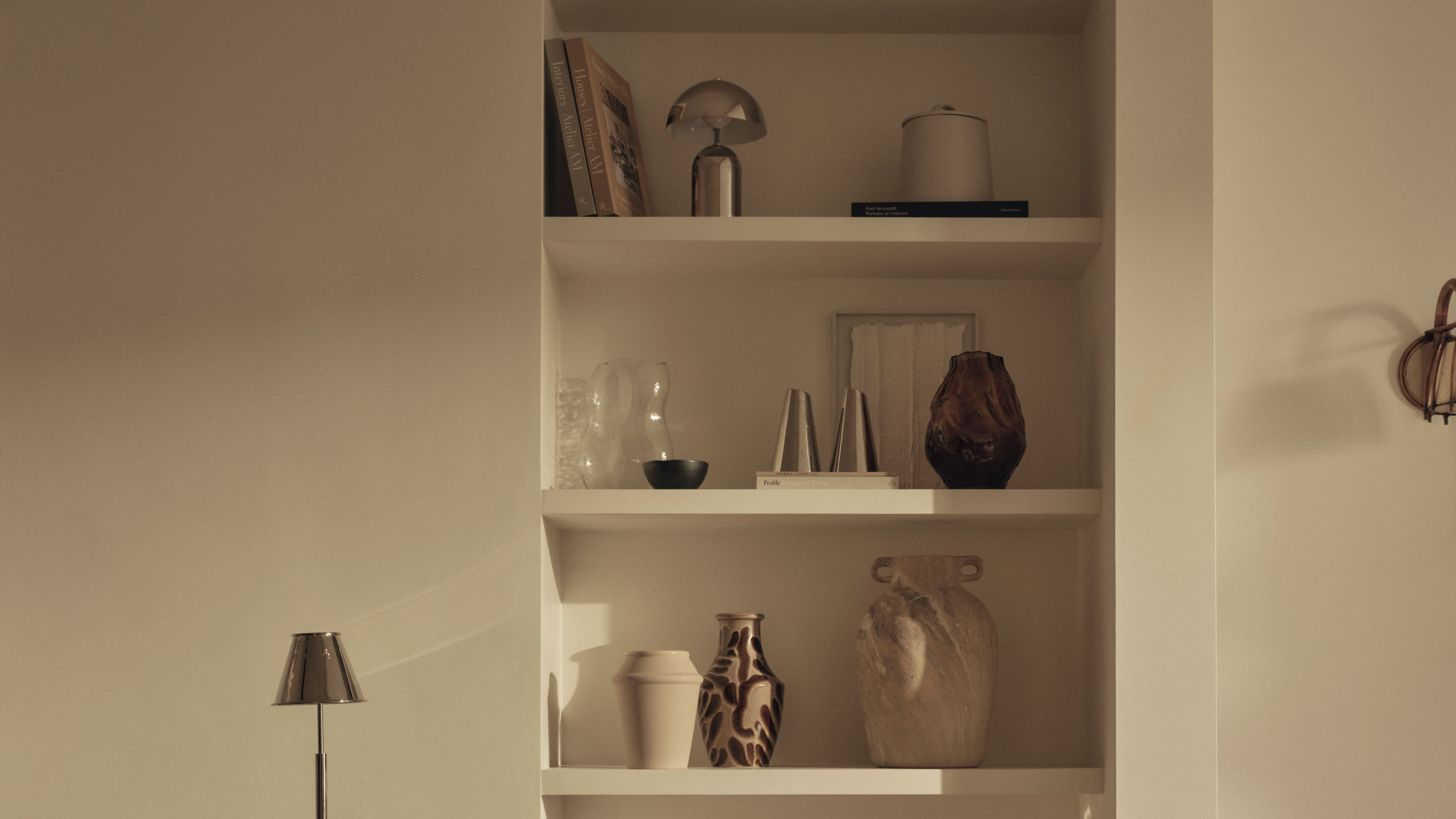 Beige colour scheme with built in shelves and chrome lighting on shelves