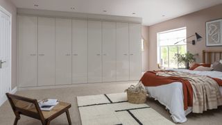 bedroom with large built-in wardrobe, king-sized bed and storage basket on floor