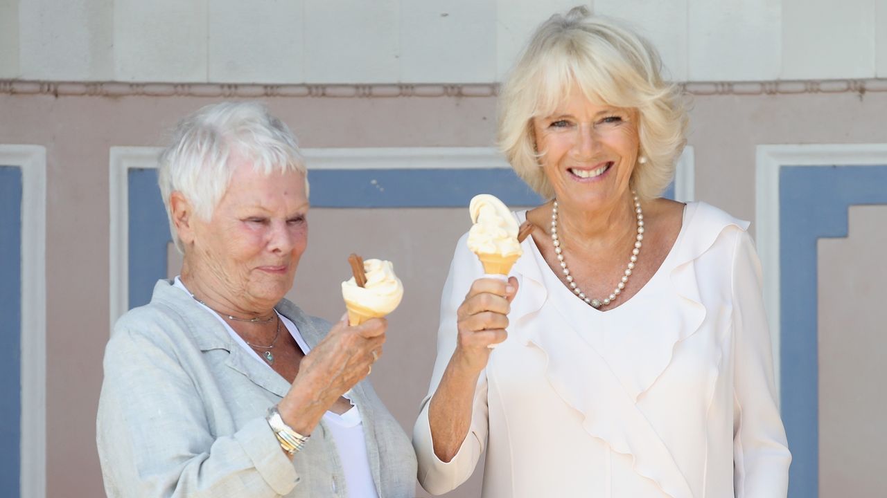 Camilla, Duchess of Cornwall enjoys an ice cream with Dame Judi Dench as she arrives at Queen Victoria&#039;s private beach, next to the monarch&#039;s holiday home, during her visit to the Isle of Wight on July 24, 2018 in Cowes, Isle of Wight, United Kingdom.