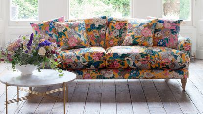 floral sofa on wooden floor with table with flowers