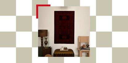 prayer mat mounted on wall in living room with lamp, ottoman, and seat with books and trinkets on it