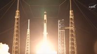 A black and white SpaceX Falcon 9 rocket is pictured launching into the night sky, surrounded by scaffold towers.