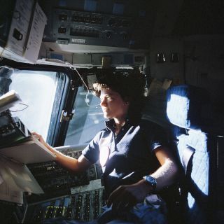 Sally Ride looking out the window of the space shuttle Challenger during the STS-7 mission in 1983.