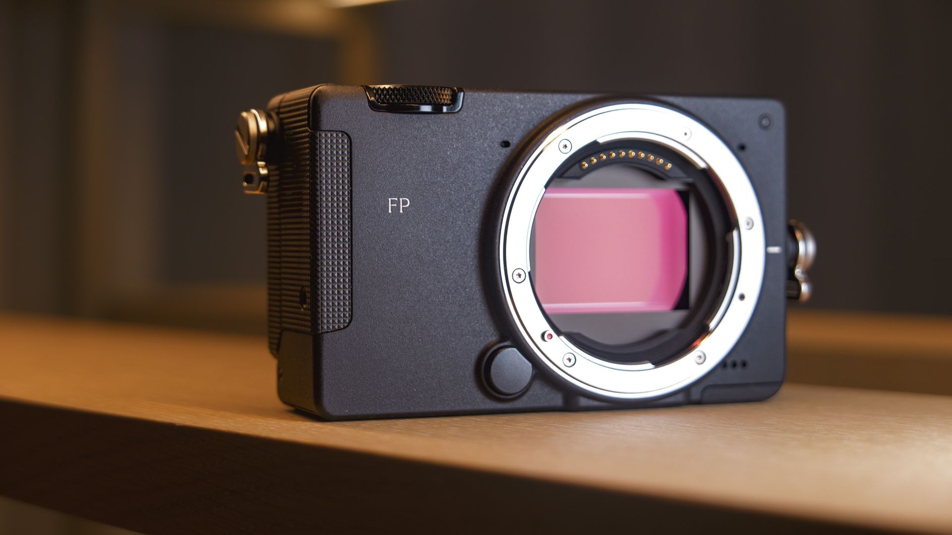 Sigma FP2 mirrorless camera no lens attached, on a shelf, lit from above