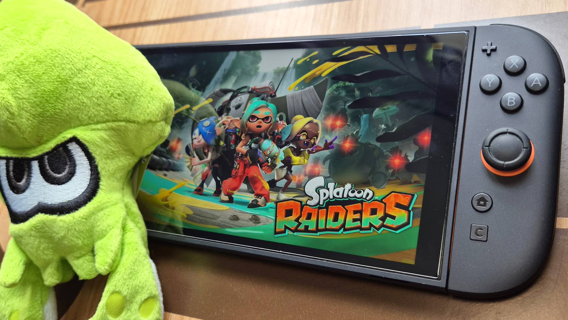 Photo of the key art from Splatoon Raiders showing on the display of a Nintendo Switch 2.