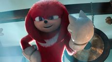 Knuckles smiles and holds his left fist up in the air in his self-titled Paramount Plus TV series