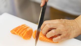 Cutting salmon on cutting board