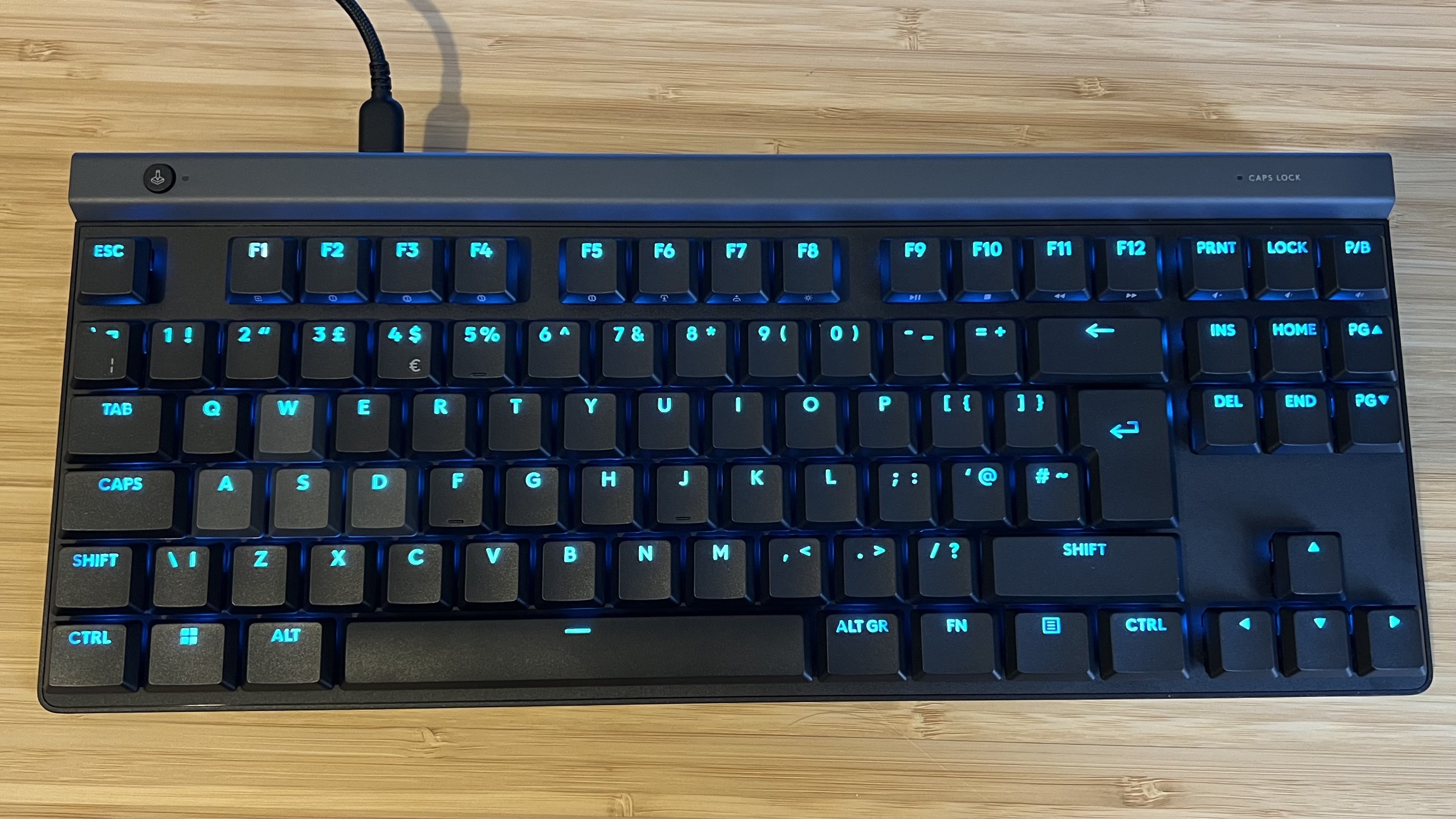 Top down view of Logitech G515 Rapid TKL gaming keyboard on a wooden desk