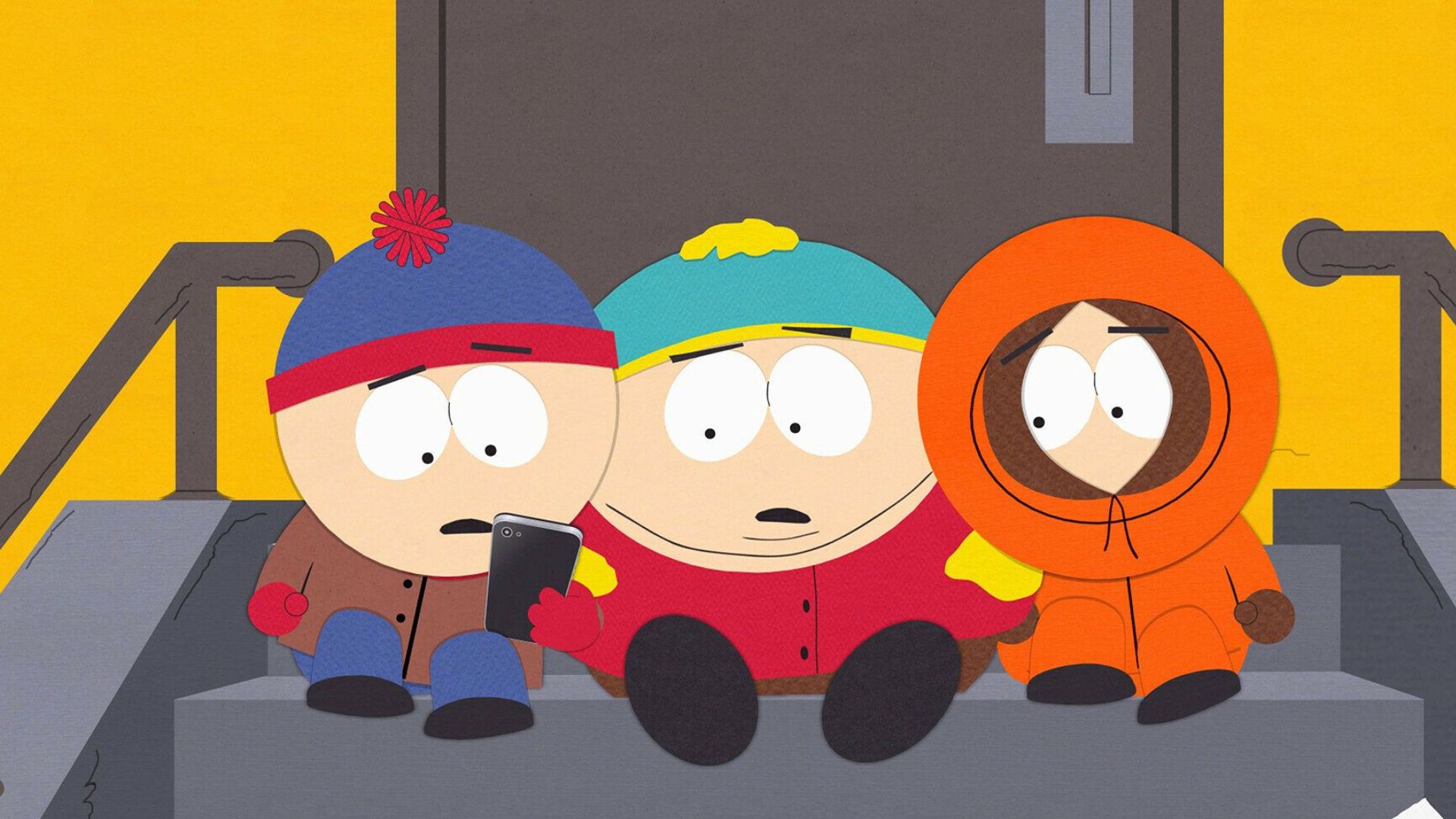Kenny, Stan and Eric look at something on Stan&#039;s phone while sitting on a staircase