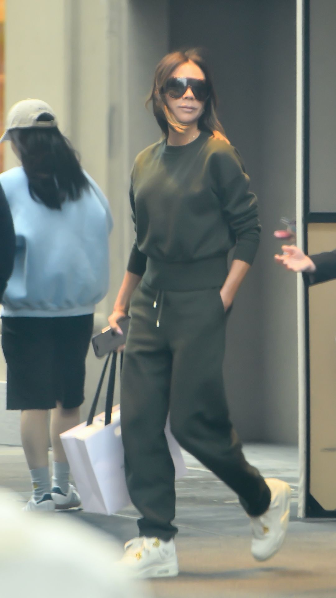VICTORIA BECKHAM WEARING A SWEATSHIRT AND JOGGERS WITH TRAINERS
