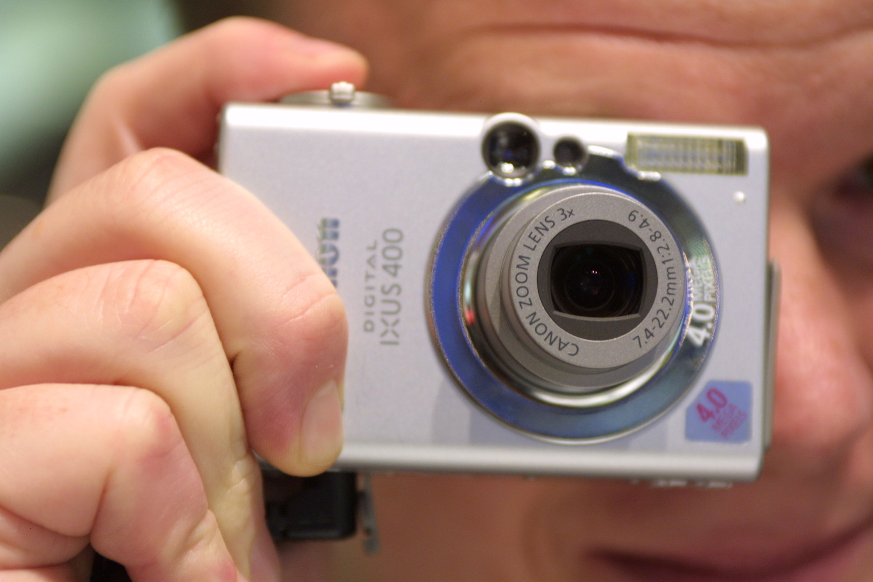 A marketing assistant demonstrates the Canon IXUS 400 digital camera at the CeBIT technology trade fair March 13, 2003 in Hanover, Germany.