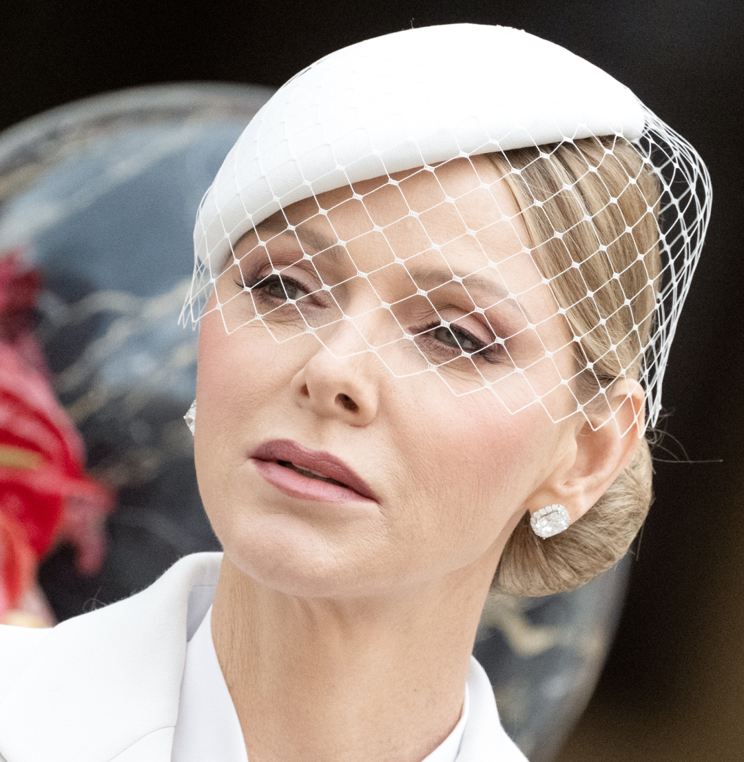 Princess Charlene wearing a white veiled hat and white suit