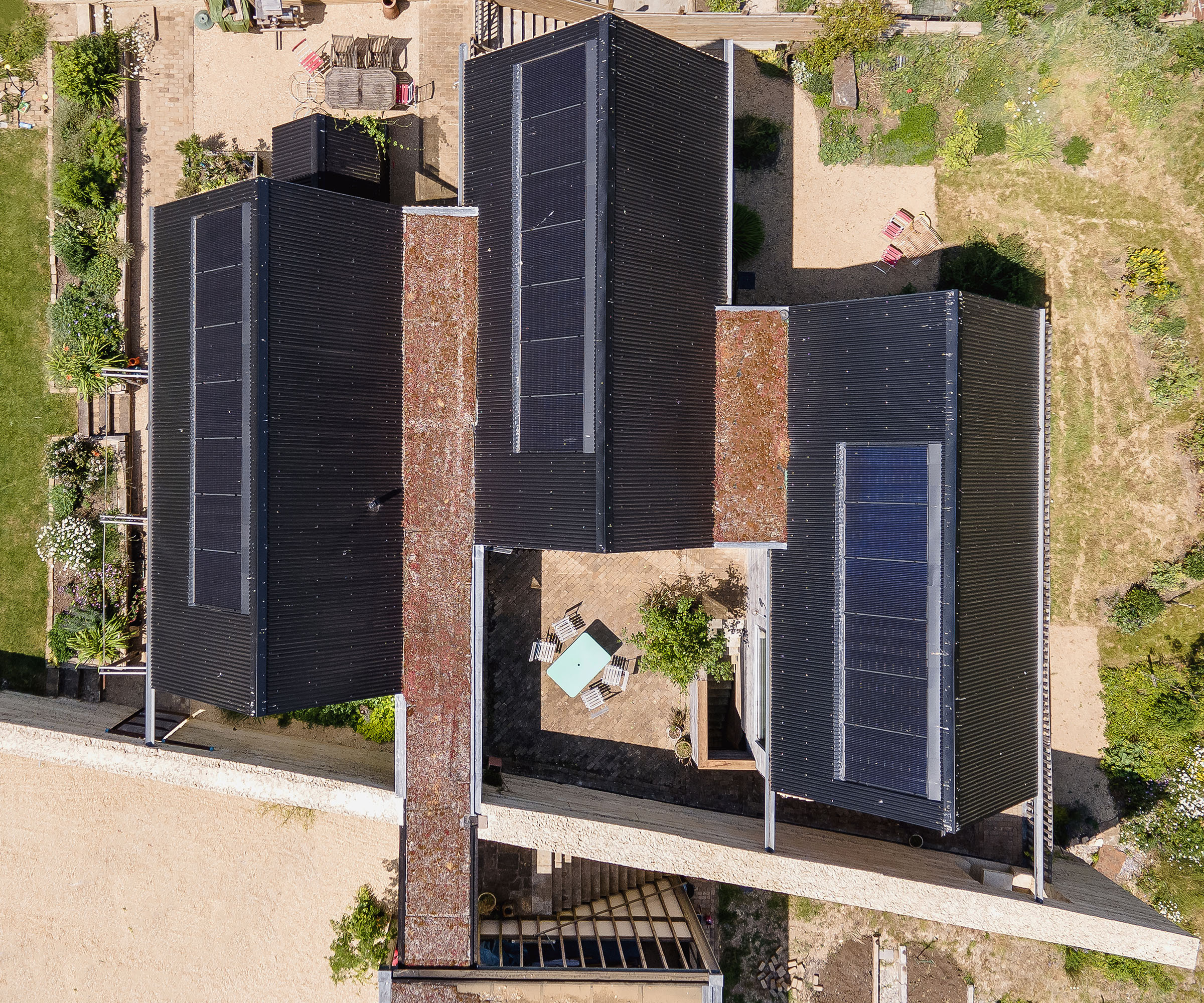 A birds-eye drone shot of three self build buildings