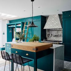 Kitchen with turquoise painted cabinetry and island and Crittal style doors