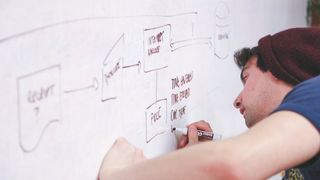 Designer writing on a whiteboard