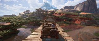 uncharted legacy of thieves collection widescreen image, a jeep drives across a wooden bridge in a red-rock valley with scrubby trees
