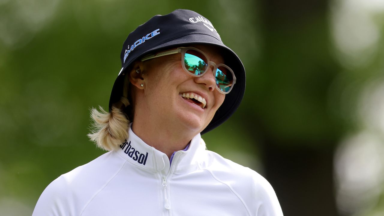 Madelene Sagstrom laughing while wearing a bucket hat and sunglasses