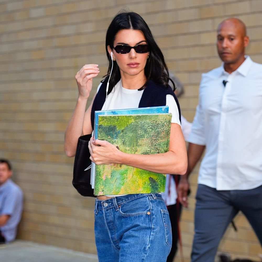 Kendall Jenner walks down the street wearing stovepipe jeans with black leather loafers and a white tee.