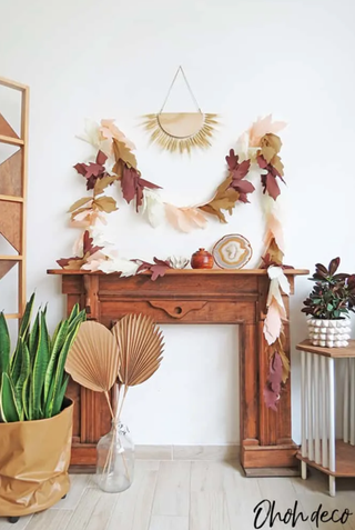 DIY fall leaf garland hanging above a fireplace
