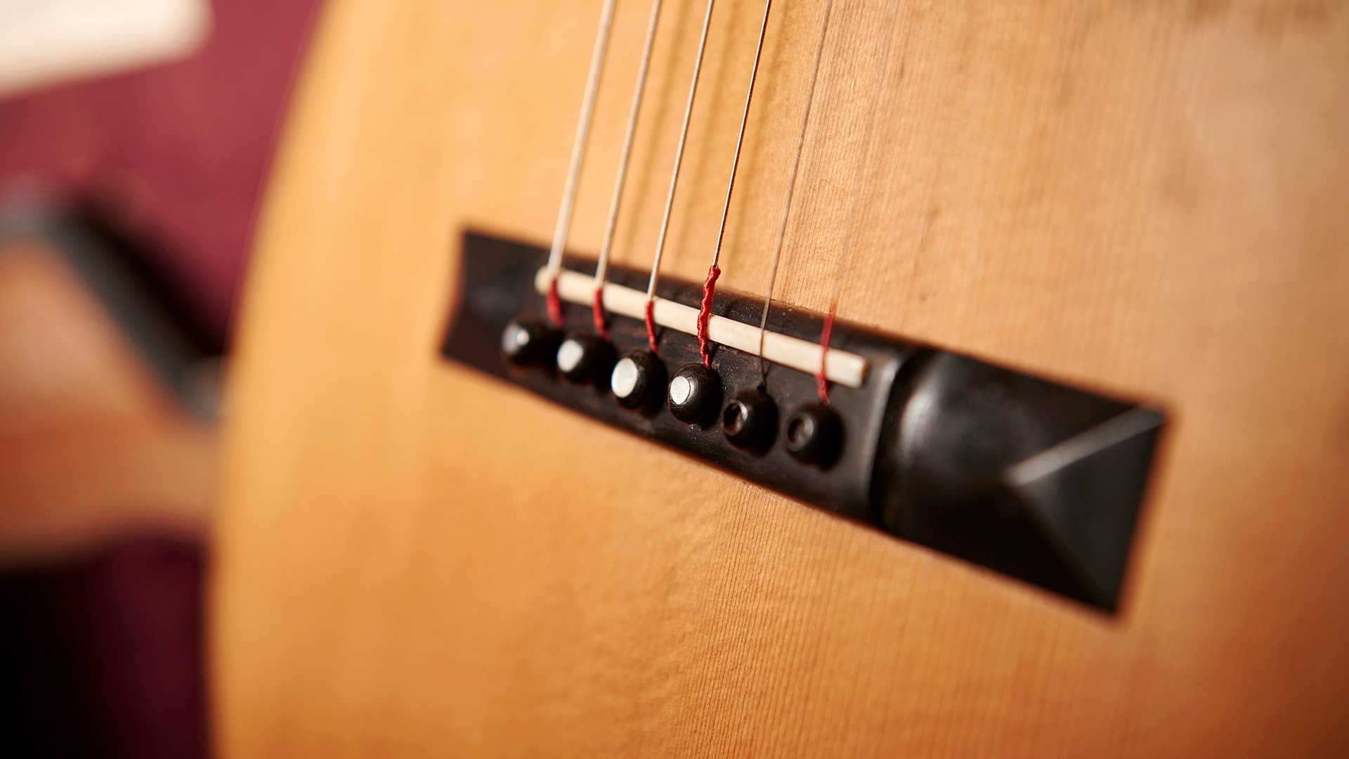 Close up of the bridge on an acoustic guitar