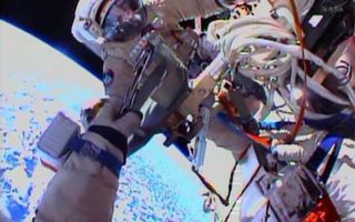 Cosmonauts Oleg Kotov, Expedition 38 commander, and flight engineer Sergey Ryazanskiy perform a spacewalk outside the International Space Station on Dec. 27, 2013. One of the cosmonauts is visible in this view from the other's spacesuit helmet camera.