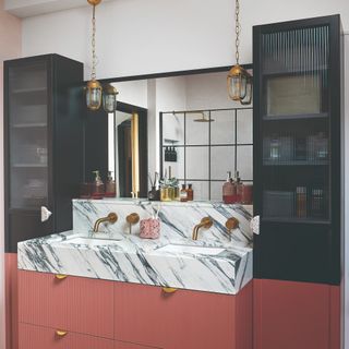 A bathroom with a marble sink and reeded glass cabinets