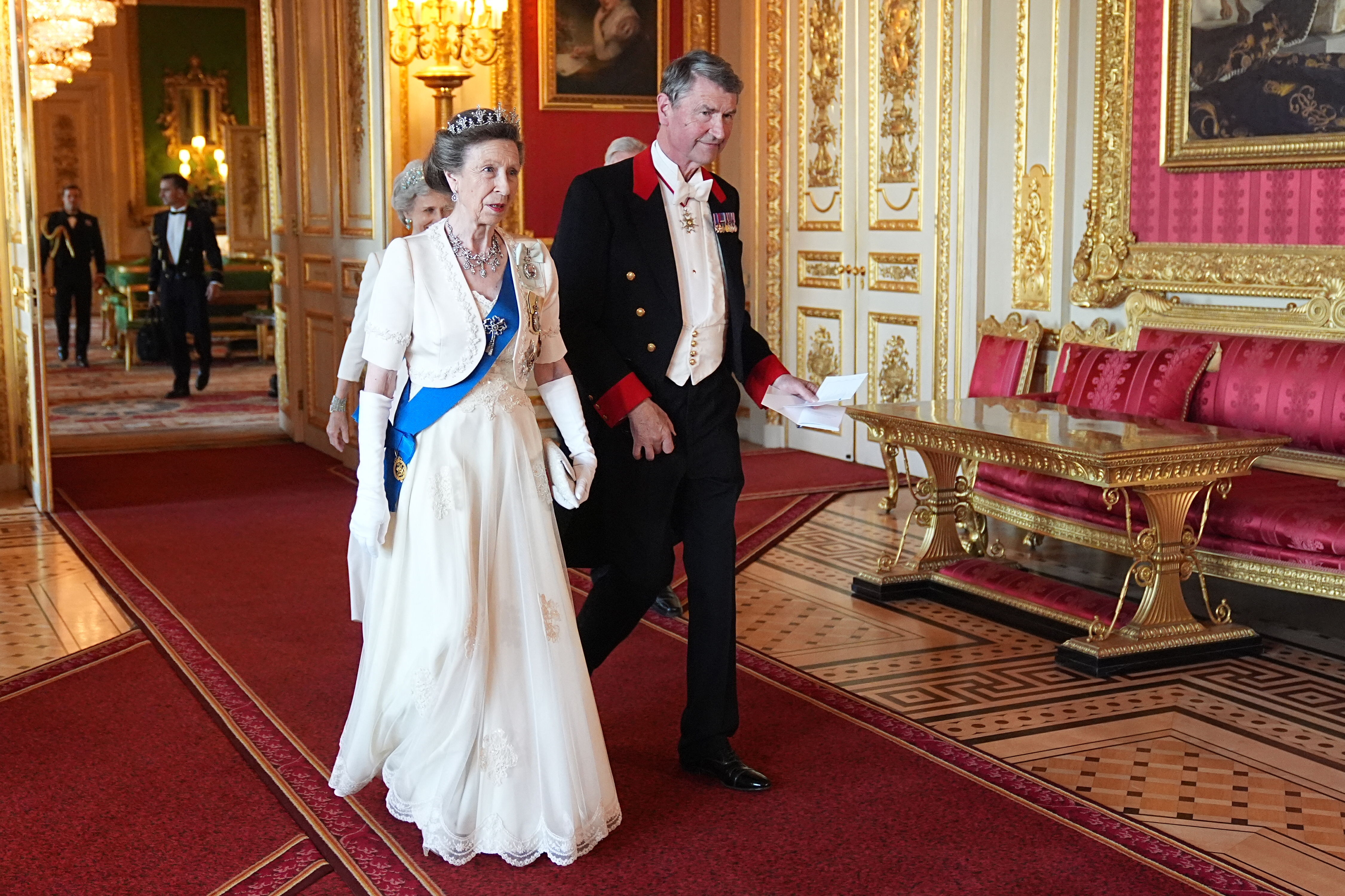 Princess Anne wearing a white gown next to Vice Admiral Sir Timothy Laurence