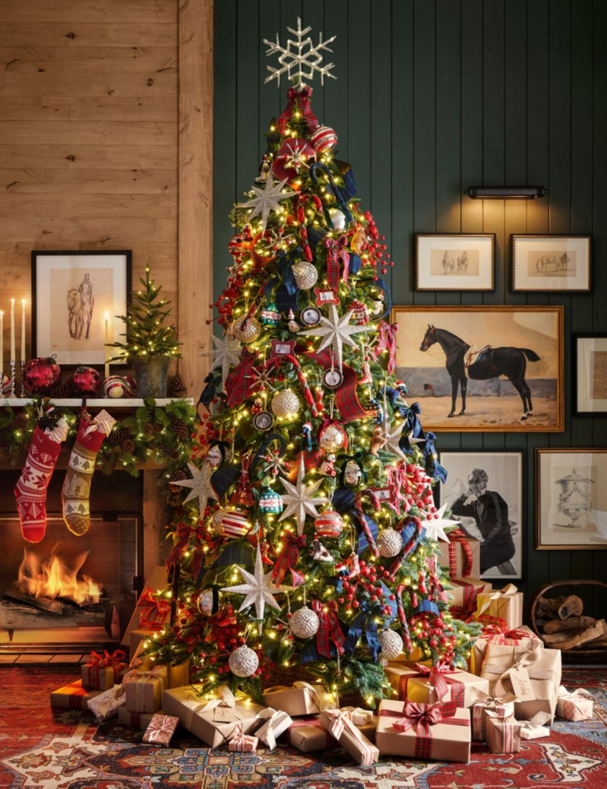 Ralph Lauren inspired Christmas living room featuring a bright, heavily decorative Christmas tree, knit stockings, and equestrian wall art.