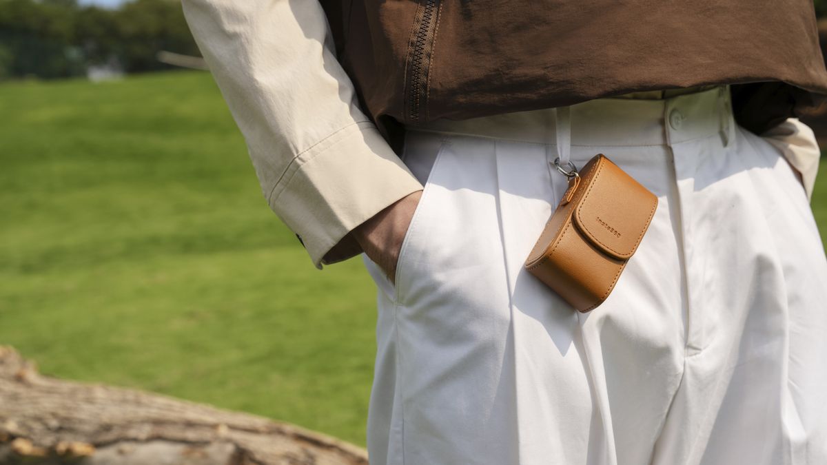 Insta360 Go 3S Retro edition inside its leather case, attached to a person's trouser belt look