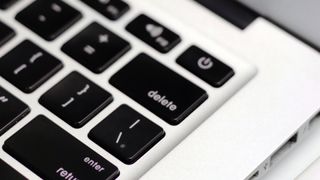 A close-up of a Mac's keyboard, showing the Delete key.