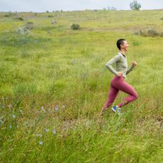 A woman running in a wildflower meadow