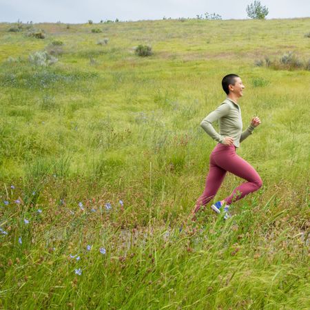 A woman running in a wildflower meadow