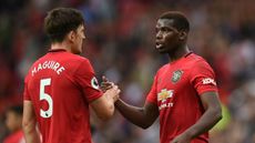 Manchester United centre-half Harry Maguire shakes hands with team-mate Paul Pogba