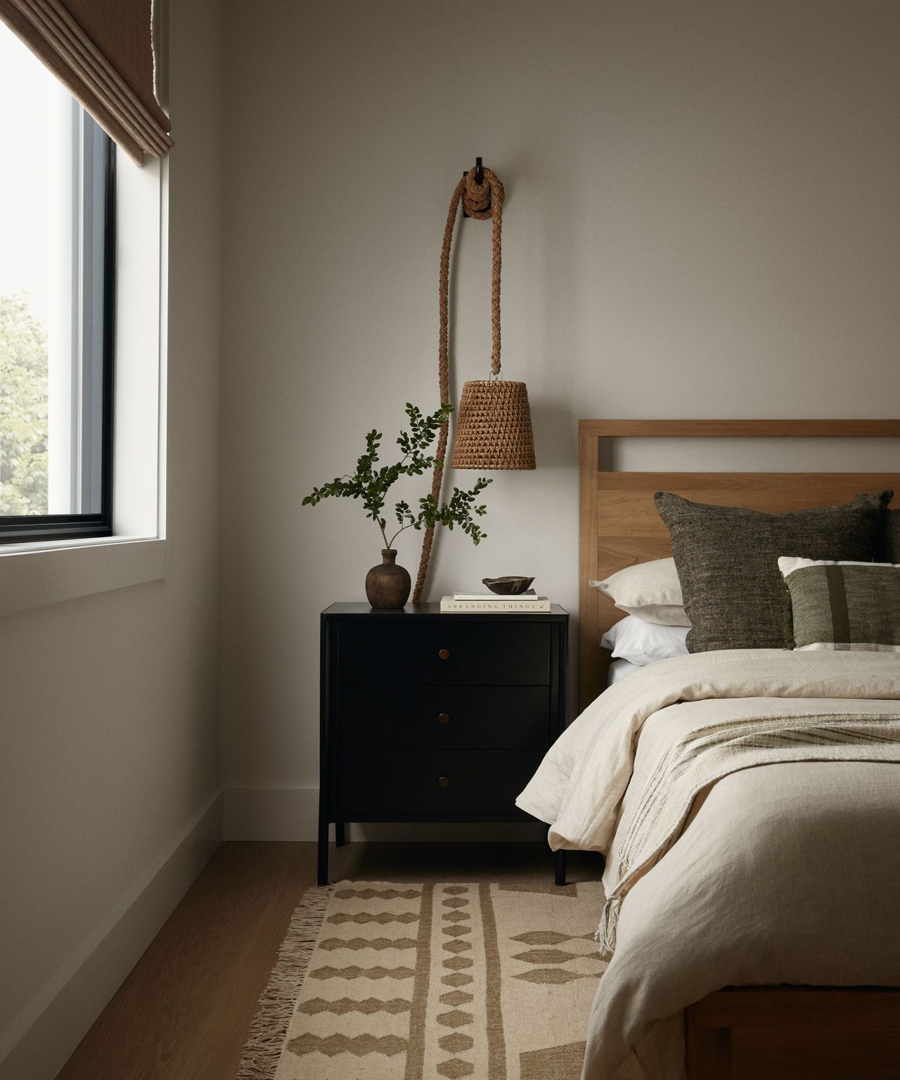 A coastal modern bedroom with a wooden bedframe and a patterned rug