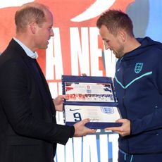 Prince William, Prince of Wales presents an England shirt to Harry Kane of England at St George's Park on November 14, 2022 in Burton upon Trent, England.