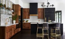 Dark mahogancy cabinetry in modern kitchen with large island and tall bar stools