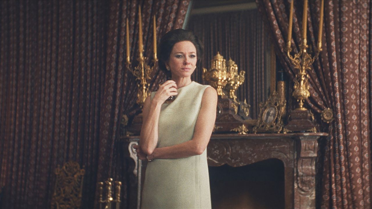 a woman (naomi watts as babe paley) stands in front of an ornate fireplace and candelabras